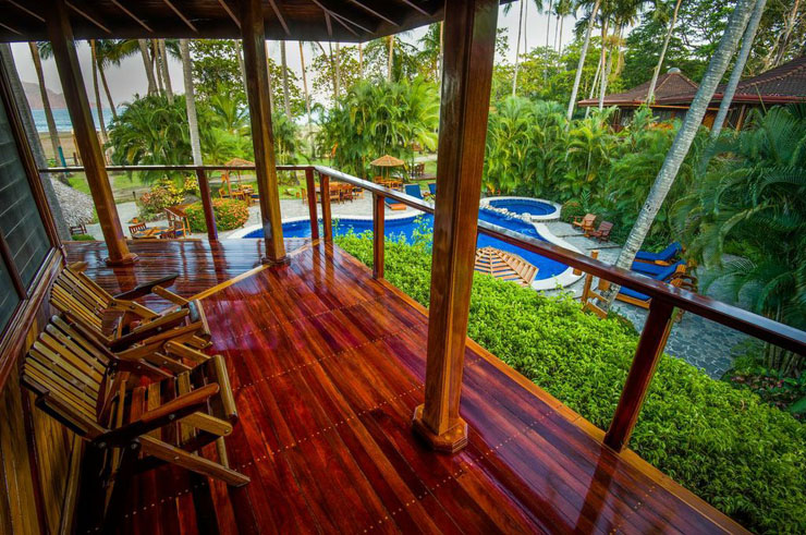 Terraza de bungalow con vistas a la piscina y el océano al fondo tambor tropical beach resort