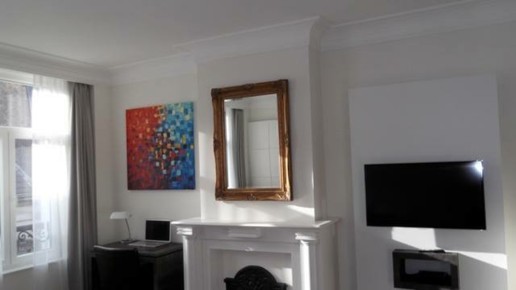 Dormitorio espacioso con techo alto y suelo de madera habitacion espaciosa hostal bruselas