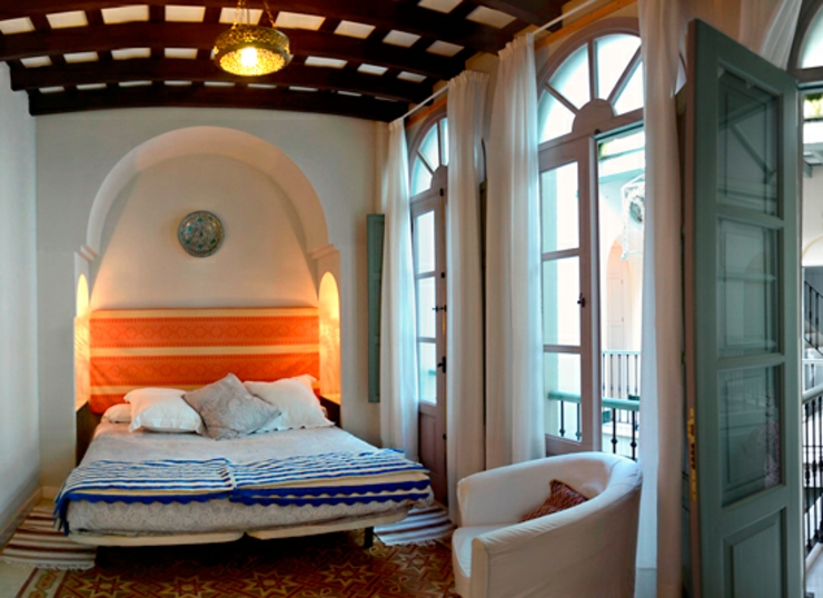 Dormitorio acogedor del pequeño hotel con salida al patio dormitorio iluminado vigas antiguas