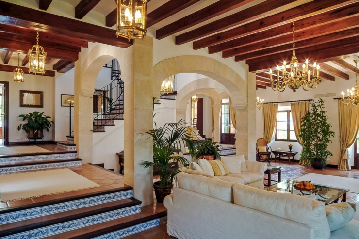 Salón diseñado en multiniveles con arcos y techos con vigas sala espaciosa villa privada