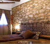 Dormitorio acogedor con pared de piedra en una casa rural en Alicante hotel rural ambiente rural