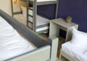 El suelo de madera y el techo alto hacen el dormitorio más amplio todavía habitacion amplia hostal plus berlin